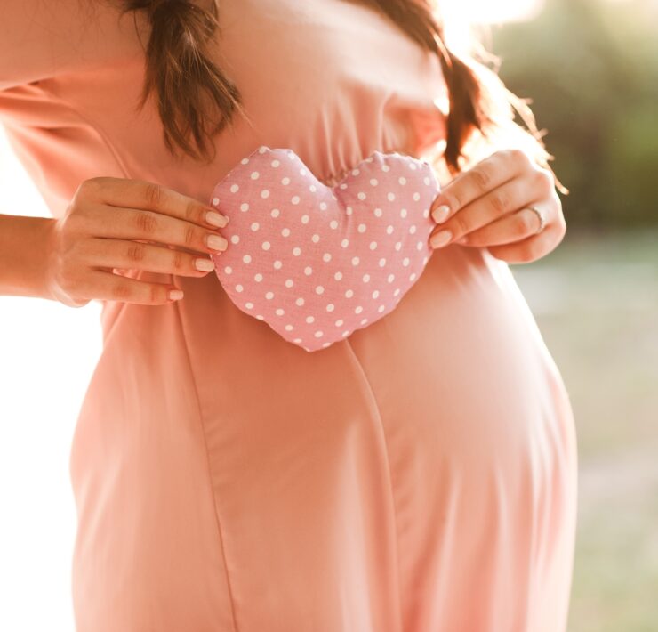 Schwangere Frau mit Kleid und Herz